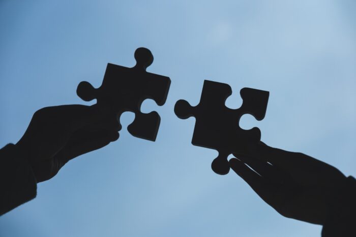 silhouette-of-two-hands-holding-and-putting-a-piec-2024-11-28-12-18-54-utc